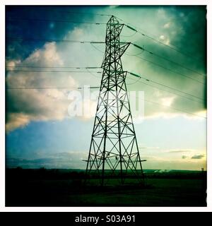 Pylône de l'électricité contre dark sun faible d'un ciel de début de soirée Banque D'Images