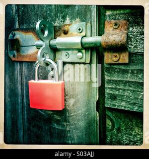 Cadenas orange sur l'abri de jardin porte. Close up. Vis rouillées. Banque D'Images