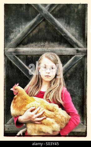 Jeune fille avec du poulet Banque D'Images