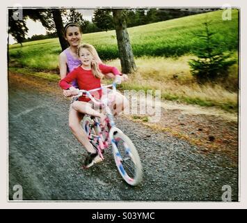 Deux jeunes filles riding bike ensemble Banque D'Images