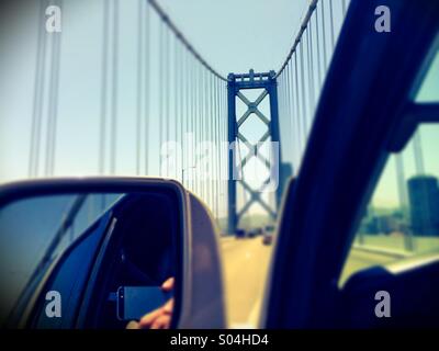 Prendre des photos de pilote distrait le Bay Bridge en conduisant. San Francisco, California, USA Banque D'Images