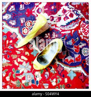 Les chaussures jaunes sur un tapis oriental aux couleurs vives Banque D'Images