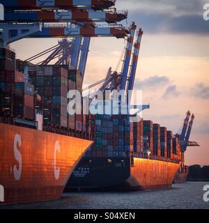 Les navires à l'Eurogate terminal à conteneurs du port de Hambourg, en Allemagne, au coucher du soleil. Banque D'Images