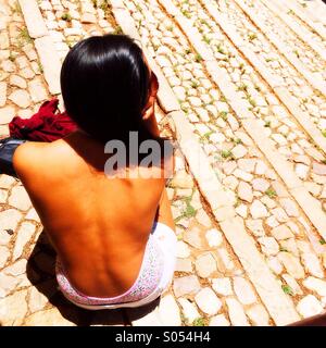Fille assise sur les marches de pierre, Portugal Banque D'Images