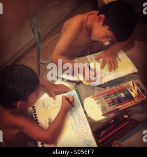 C'est une photo de deux enfants faire devoirs. Ils sont deux brothets rassembler Banque D'Images