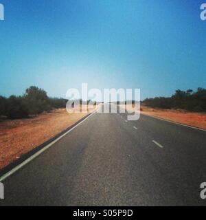 Et longue route droite dans l'ouest de l'outback australien Banque D'Images