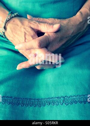 Woman's hands clasped dans lap Banque D'Images