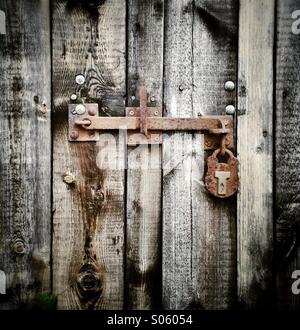 Vis rouillées et d'un cadenas sur une vieille porte de grange Banque D'Images