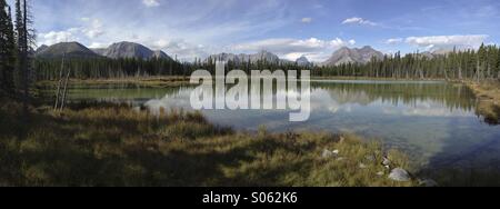 Panorama de montagnes reflétée dans un étang calme dans la région de Kananaskis, Alberta, Canada. Banque D'Images