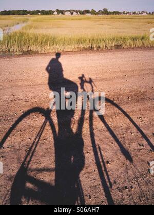 L'ombre d'un homme sur une bicyclette sur un chemin en Nouvelle Angleterre, USA. Banque D'Images
