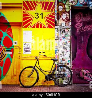 Un vélo appuyé contre un mur de graffiti sur elle. Amsterdam aux Pays-Bas. L'Europe. Banque D'Images