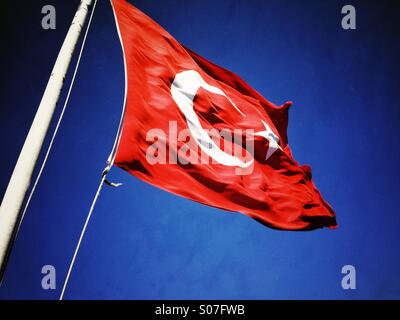 Le drapeau de la République de Turquie. Un drapeau rouge avec une étoile blanche 5 et croissant de lune blanc voletant dans un ciel bleu. La vexillologie. Al Bayrak. Baptisé « Sancak Al. Banque D'Images
