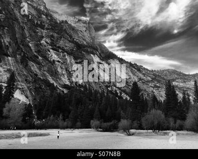 Le lac Miroir à sec à l'automne. La vallée Yosemite, en Californie, aux Etats-Unis. Garçon solitaire marche sur dry lake bed. Photo en noir et blanc. Banque D'Images