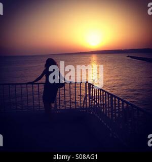 Woman looking at sunset Banque D'Images