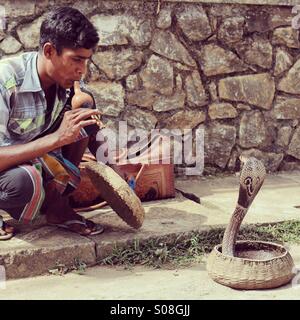 Charmeur de serpent et son cobra sur le côté de la route au Sri Lanka Banque D'Images