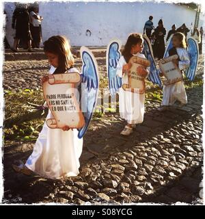 Les enfants costumés en mars pendant la procession Semana Santa, à Antigua, Guatemala. Banque D'Images