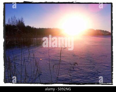 Coucher de soleil sur un lac gelé en Finlande Banque D'Images