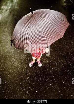 Petite fille sous un parapluie Banque D'Images