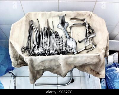 Medical instruments chirurgicaux sur un plateau couvert de vieux tissu dans un hôpital en Philippines Banque D'Images
