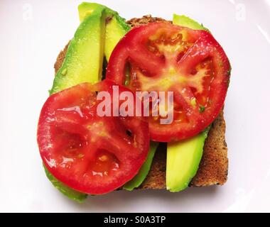 Sandwich de légumes ouvert sur pain de blé entier avec de l'avocat et de tomate Banque D'Images