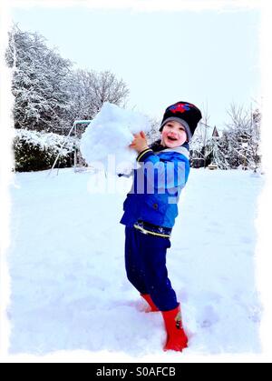 Garçon aux grands snowball. Faire un bonhomme de neige. Banque D'Images