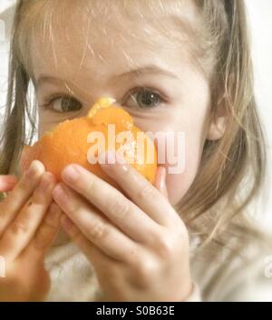 Tout-petit mange Orange Banque D'Images