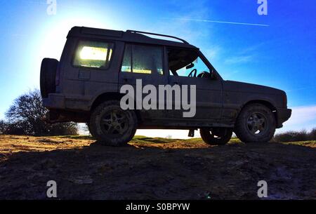 Land Rover Discovery off-road silhouetted against a blue sky Banque D'Images