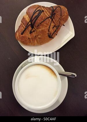 Petit-déjeuner typiquement italien au bar avec une tasse de Cappuccino et un pain au chocolat Banque D'Images