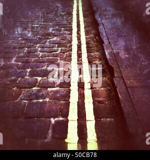 Chambre double lignes jaunes peintes sur la rue pavée England UK Banque D'Images