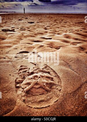 Empreinte dans le sable à Crosby Beach avec Antony Gormley statue (partie d'un autre lieu de l'installation) en arrière-plan Banque D'Images