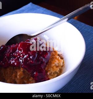 Le petit-déjeuner. Gruau chaud saupoudré de sucre d'érable, la cannelle et la confiture de petits fruits mélangés dans un bol blanc. Banque D'Images