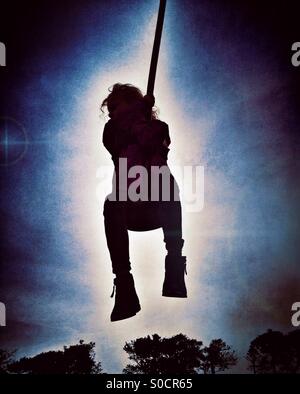 Jeune fille en silhouette sur zip wire Banque D'Images