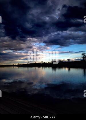 Sombres nuages survoler un lac tranquille (1). Banque D'Images