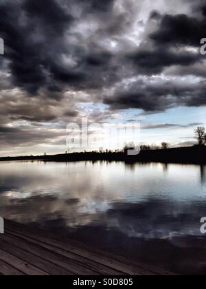 Sombres nuages survoler un lac tranquille (3). Banque D'Images