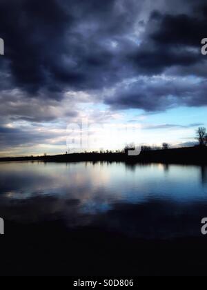 Sombres nuages survoler un lac tranquille (4). Banque D'Images