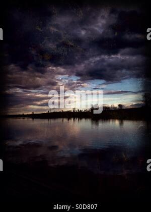 Sombres nuages survoler un lac tranquille (5). Banque D'Images