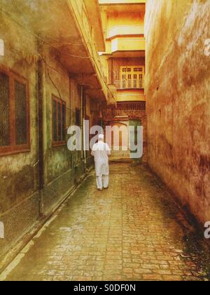 Vieil homme se promenant dans le village Kharian Pakistan Banque D'Images