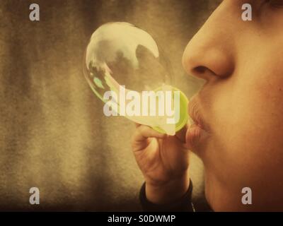 Boy blowing bubbles Banque D'Images