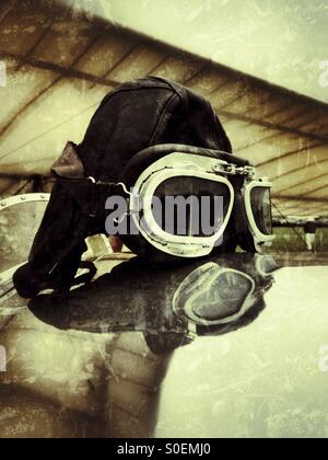 Casque de vol en cuir sur le couvercle d'un poste de pilotage des avions d'époque. Ancien directeur de l'aérodrome, Bedfordshire, Angleterre. Banque D'Images