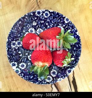 Les fraises sur une plaque floral bleu et blanc. Banque D'Images