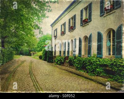 Vue de la Maison du jardinage avec de jolis volets bleus au Parc de Bercy à Paris, France. Revêtement de brique, Arbres et feuillage frais du printemps avec incrustation de texture vintage. Banque D'Images