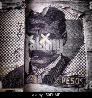 Une reproduction d'un peso mexicain avec bill héros révolutionnaire Emiliano Zapata avec ses yeux couverts de croix et un troisième œil décorer une rue dans la ville de Mexico Banque D'Images