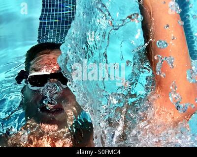 Libre Vue de dessus au-dessus de l'eau splash à partir de mi- nageur, dos dans une piscine olympique piscine de 25 mètres. Banque D'Images