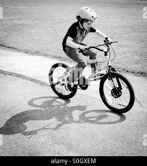 Boy riding sa bicyclette- ombre. Banque D'Images