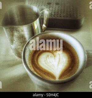 Tasse de café à côté d'une machine à expresso et d'une cruche Banque D'Images