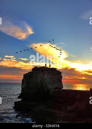 Deux hommes sur Pulpit Rock Portland bill au coucher du soleil Banque D'Images