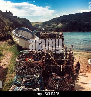 Des casiers à homard et bateau à rames, Hope Cove, Devon, Angleterre, Royaume-Uni. Banque D'Images