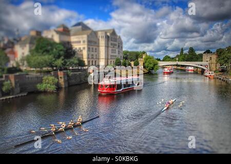 Une longue rivière Ouse dans la ville de New York avec les deux bateaux de touristes et les barques. Blocs de bureau moderne et médiévale des ponts. Banque D'Images