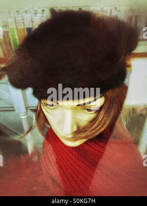 Tête de mannequin de boutique, dans une vitrine,fourrure beret et foulard rouge. Banque D'Images