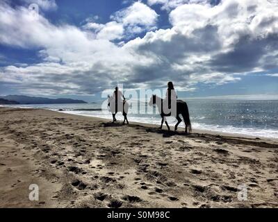 Deux cavaliers à cheval vers le sud sur une longue étendue de la plage Californie Banque D'Images